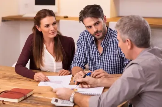 Business coach reviewing financial graphs with two business owners