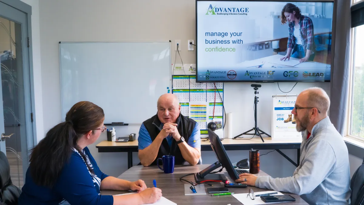 Business coach reviewing financial graphs with two business owners