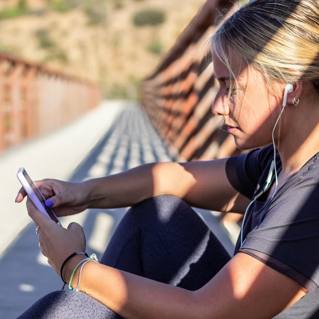 runner reading on her phone during training brea