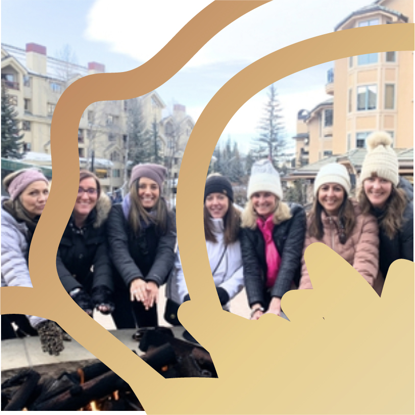 Group of friends posing together outdoors in a city setting, smiling while bundled up in winter clothing.
