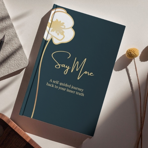 Teal book cover titled “Say More” with a gold poppy illustration and the subtitle “A self-guided journey back to your inner truth.”