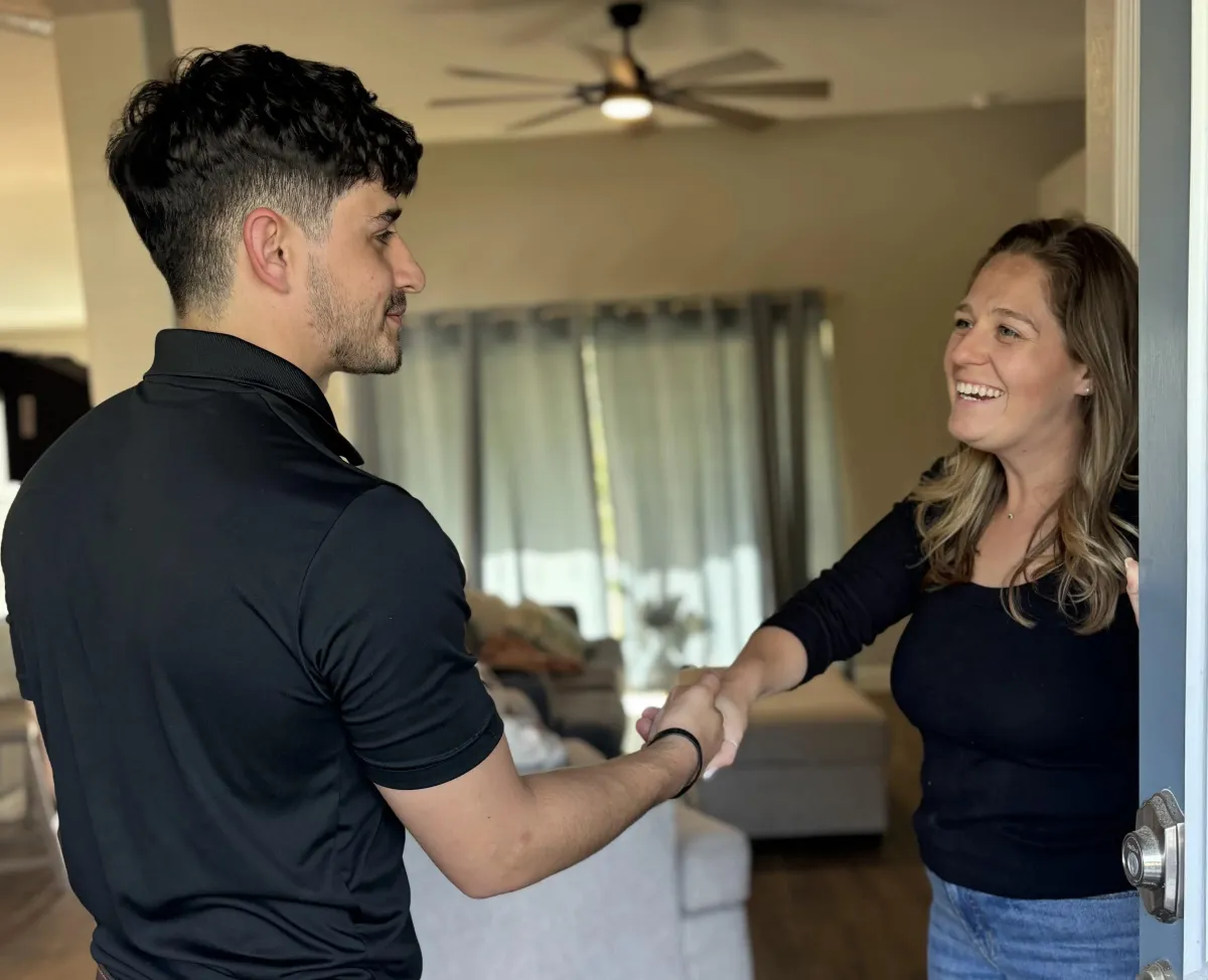 Plumbing talking to woman in kitchen. 