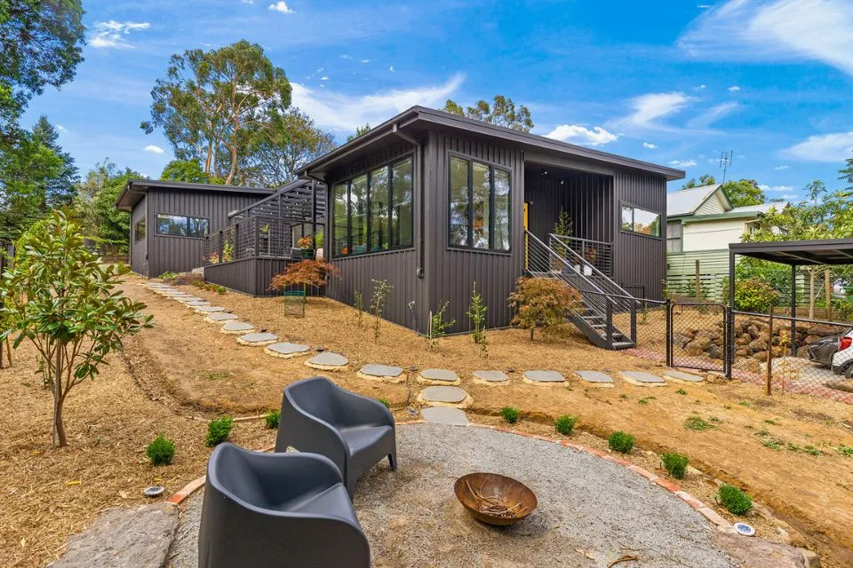 Modern outdoor courtyard with firepit, seating, and gravel landscaping