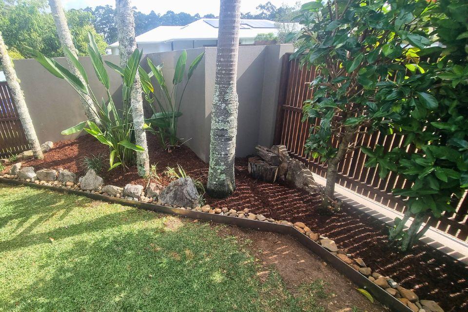 Buderim garden makeover featuring steel garden edging, Mary River rock feature garden, and fresh tea tree mulch