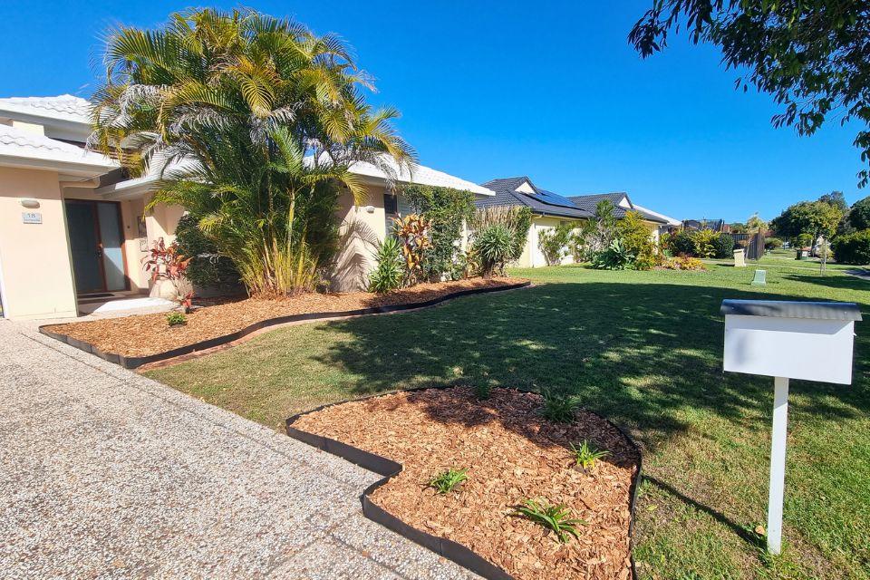 Landscaped garden pathway with tropical planting and fresh mulch