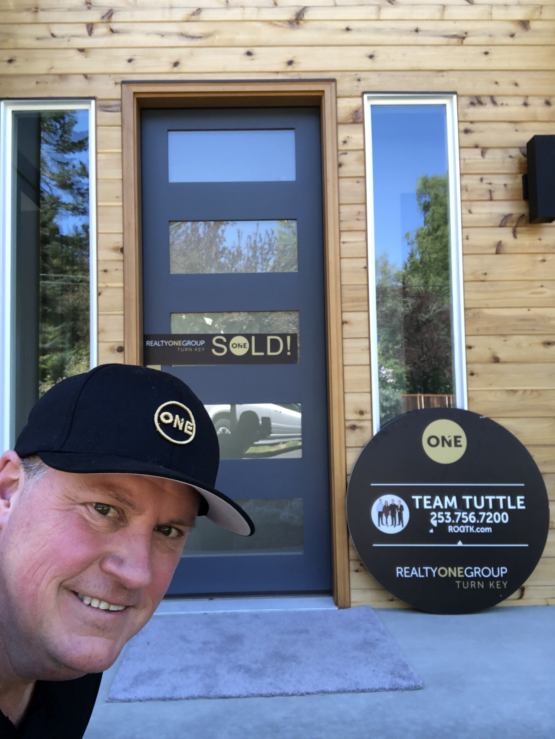 Craig Tuttle standing along Tacoma waterfront with city and mountains in background