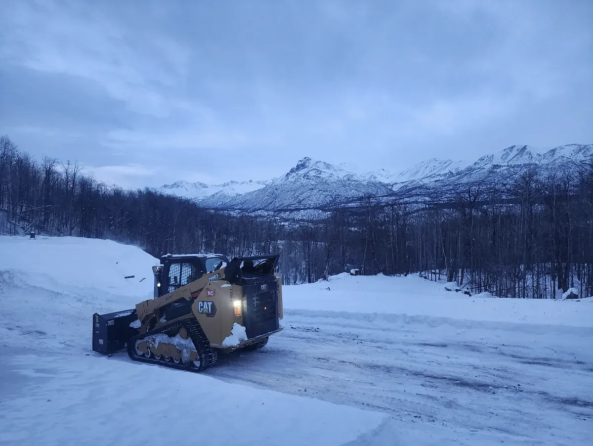 a person standing in the snow with a snow blower