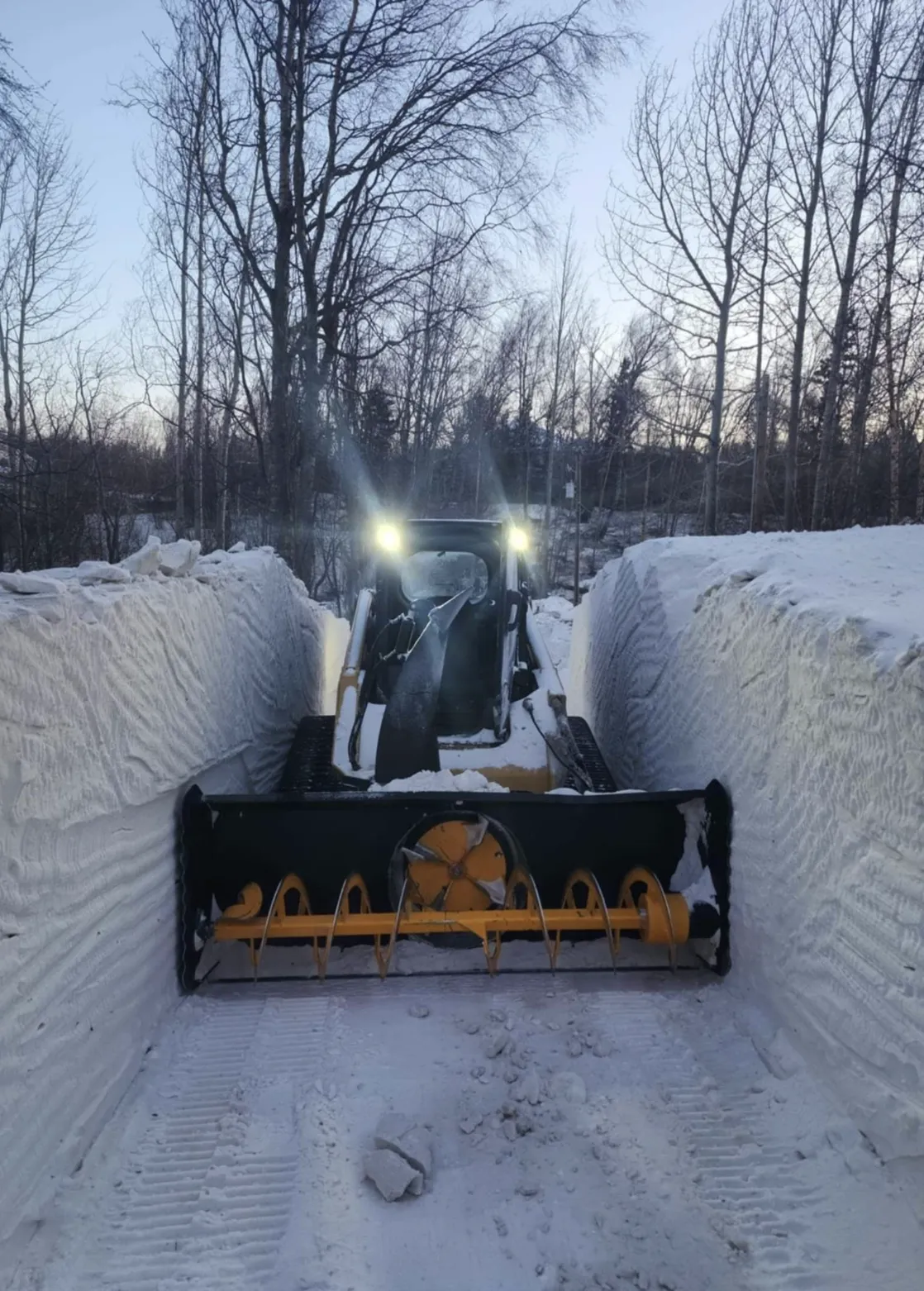 a large bulldozer digging through the snow