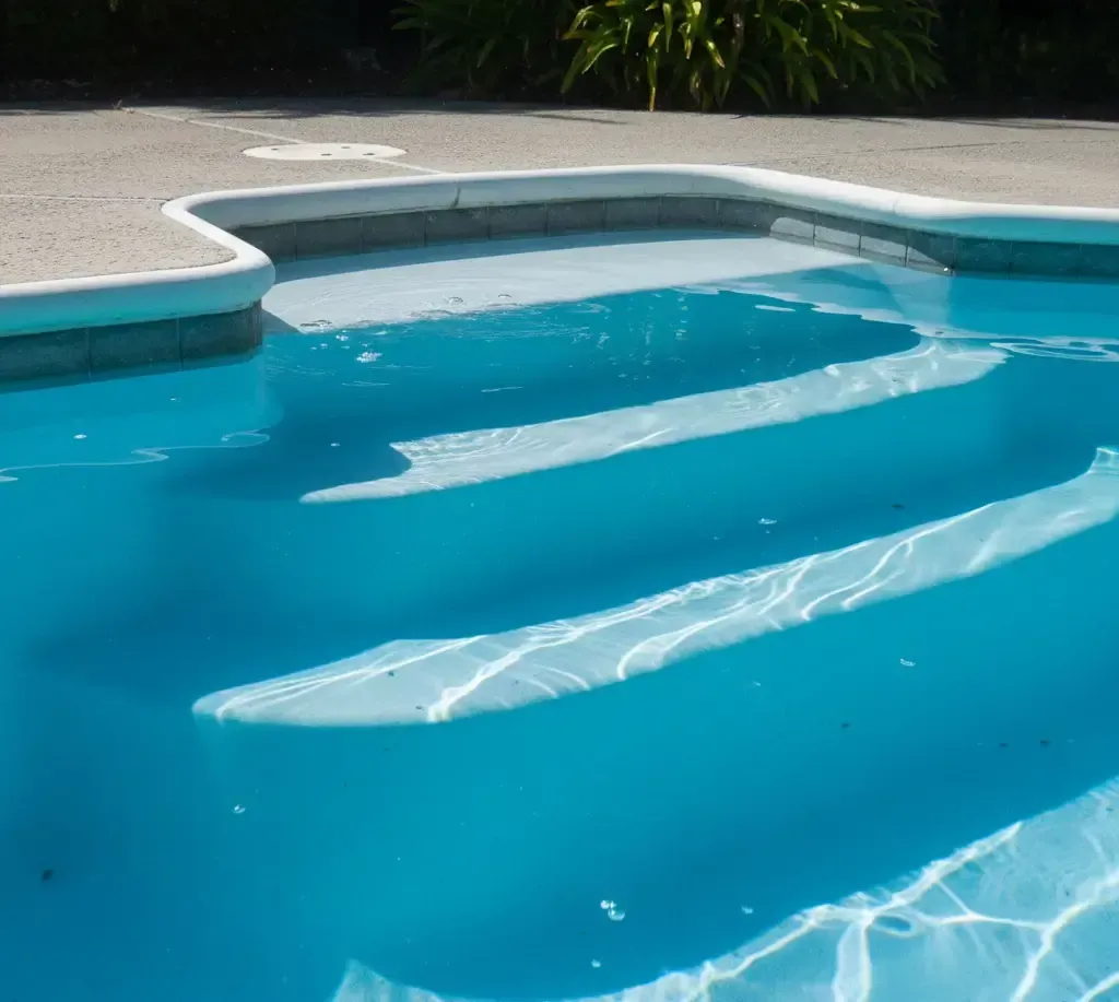 Pool cleaning tools and water test strips on a table beside a cloudy backyard swimming pool, showing pool maintenance and water chemistry testing