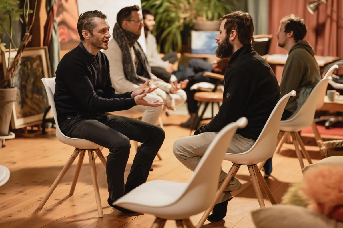 Members of Koherence Brotherhood engaged in a men's circle at an event
