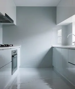 man in orange and black jacket and blue denim jeans jumping on gray concrete floor under