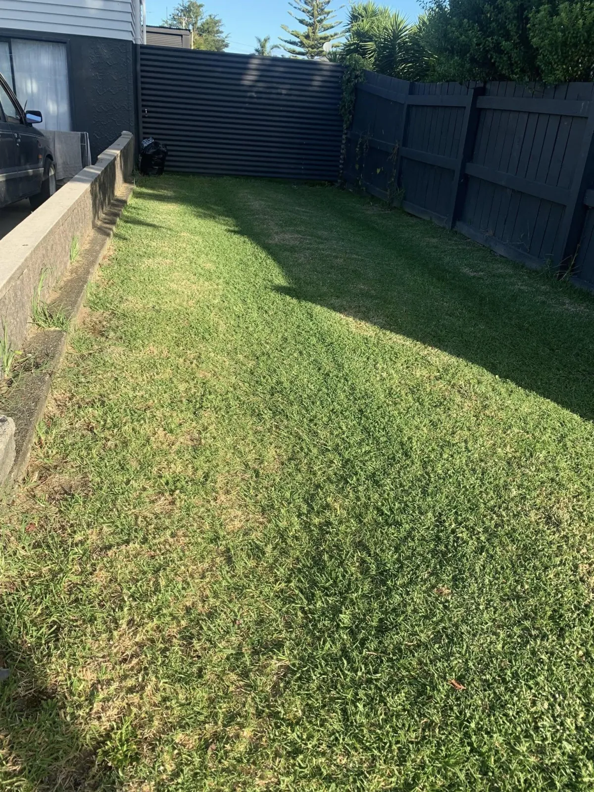 Neatly mowed side yard lawn by Tiki Blasting exterior cleaning in Gisborne