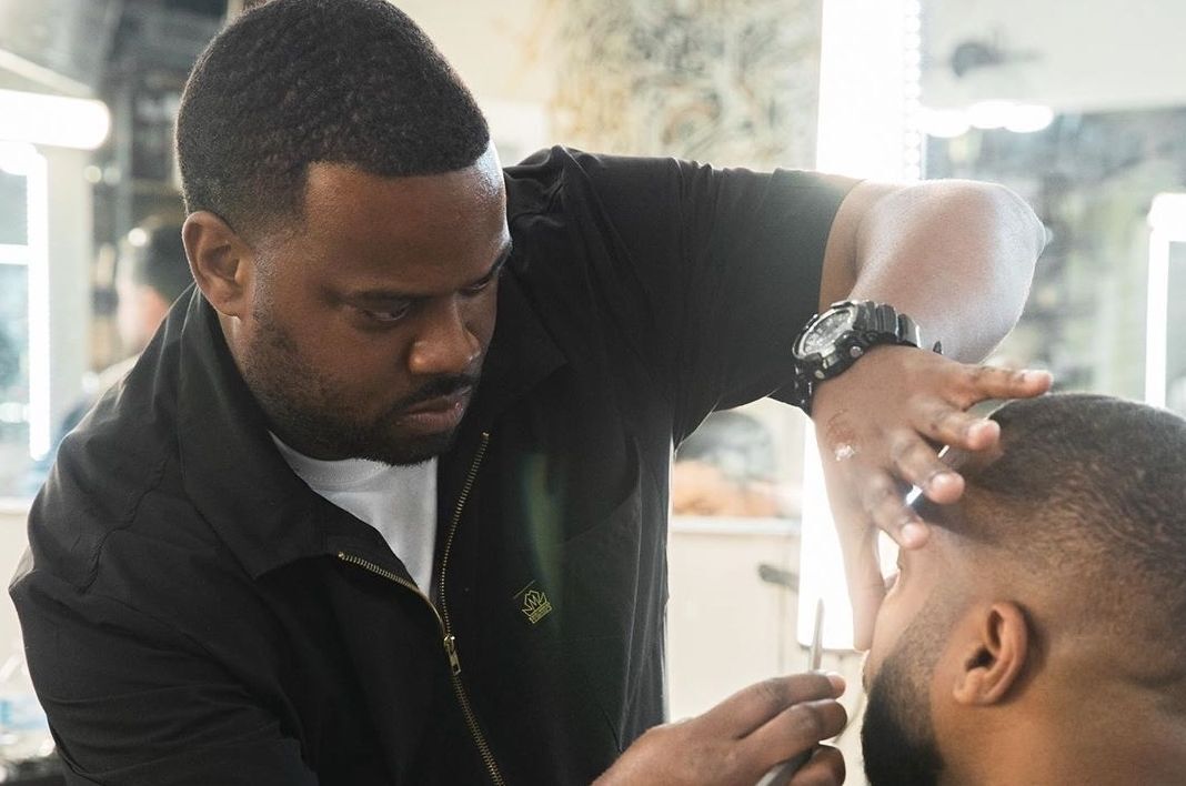 Barber Johnie J giving a premium haircut to a client in Chicago River North studio