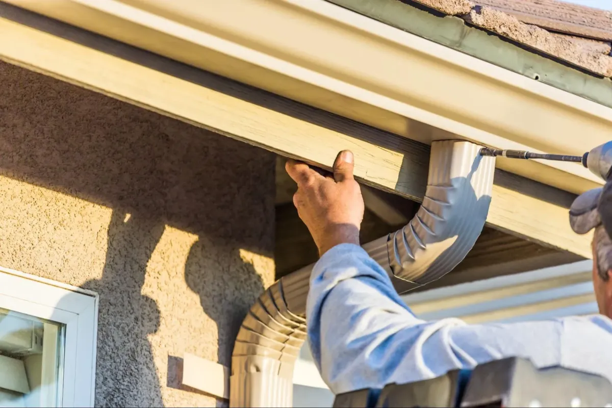 Gutter installation on residential home in Missouri showing downspouts and exterior drainage system