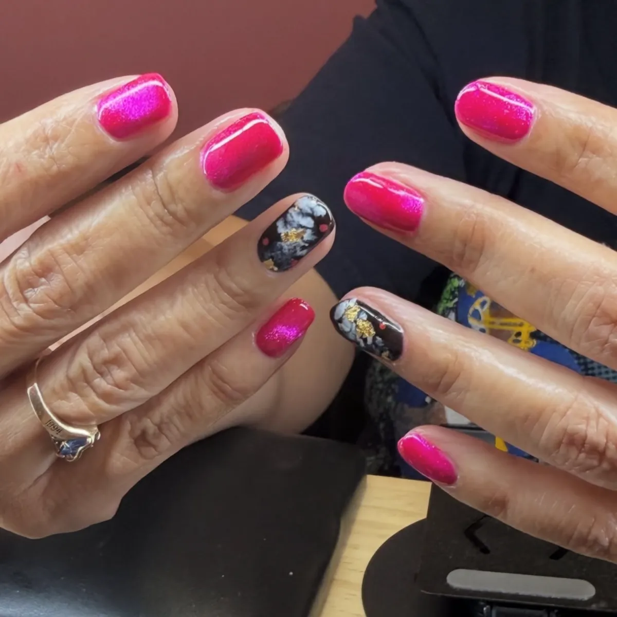 Close-up of manicured hands showing nail polish details.