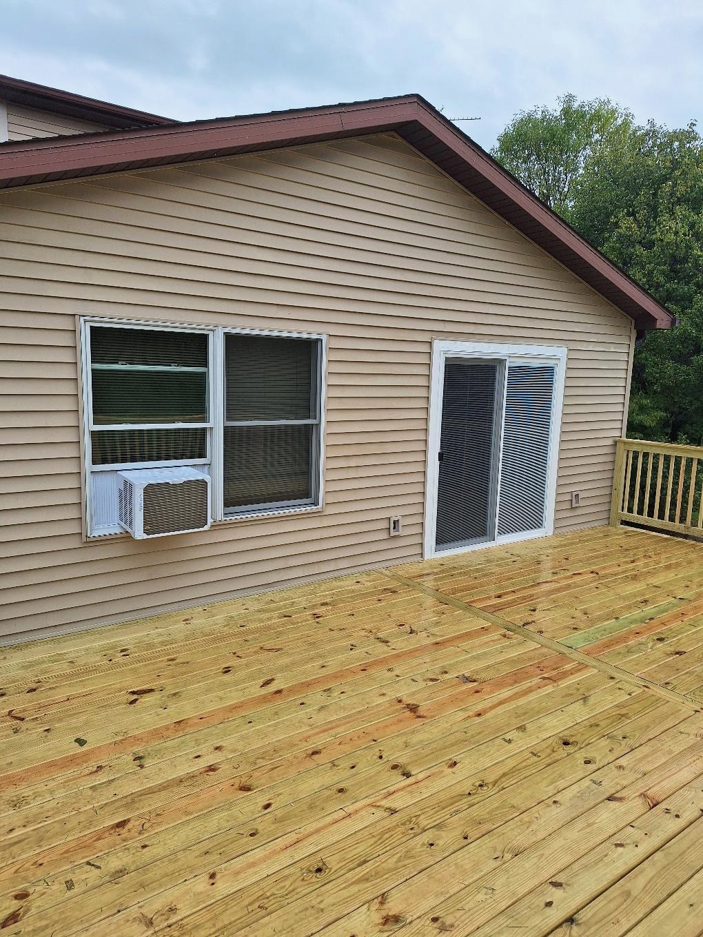A newly constructed wooden deck featuring pressure-treated lumber, installed by Precision Exterior Inc.