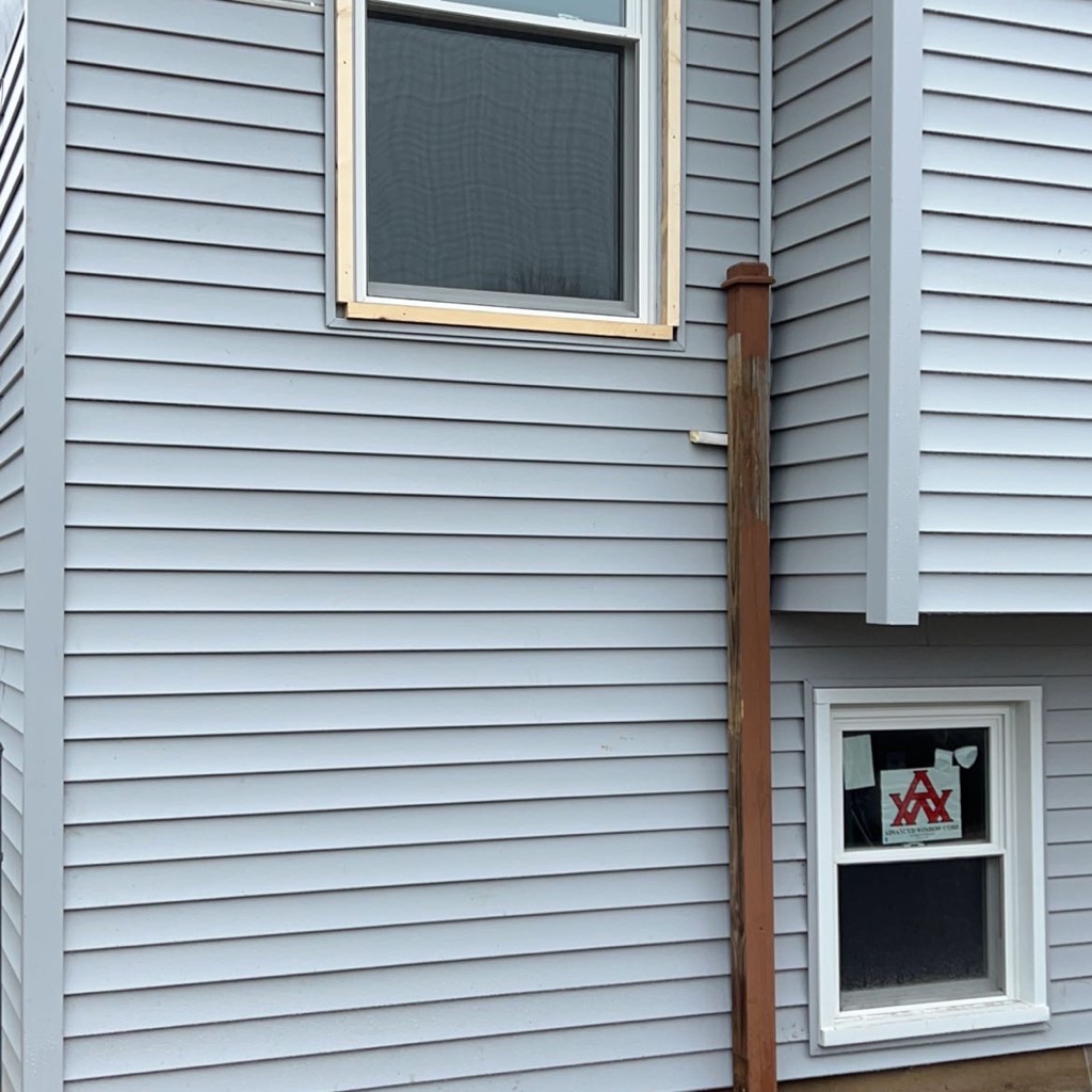 Close-up view of new light blue horizontal siding panels.