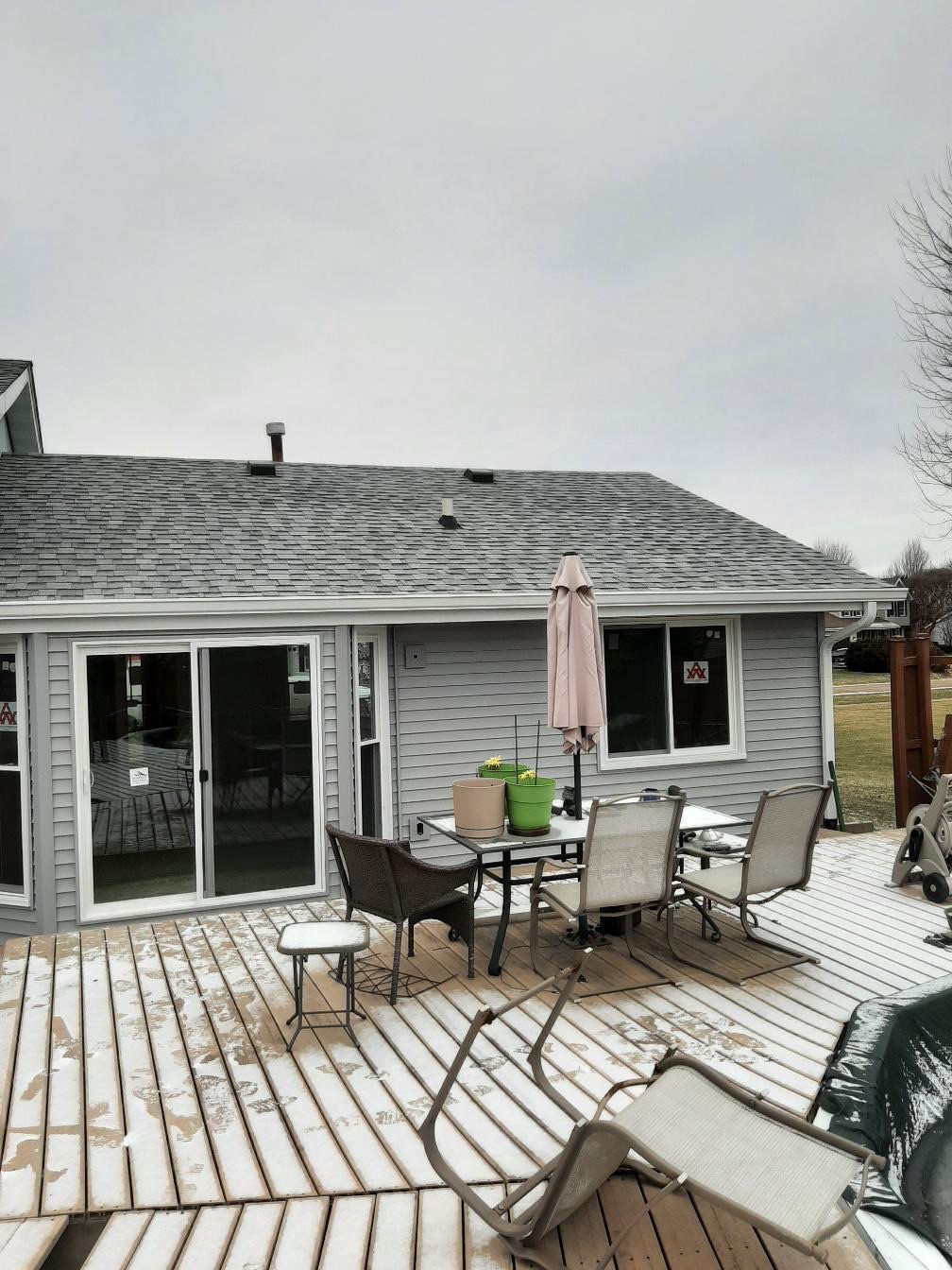 Backyard view of a house with freshly updated gray siding.