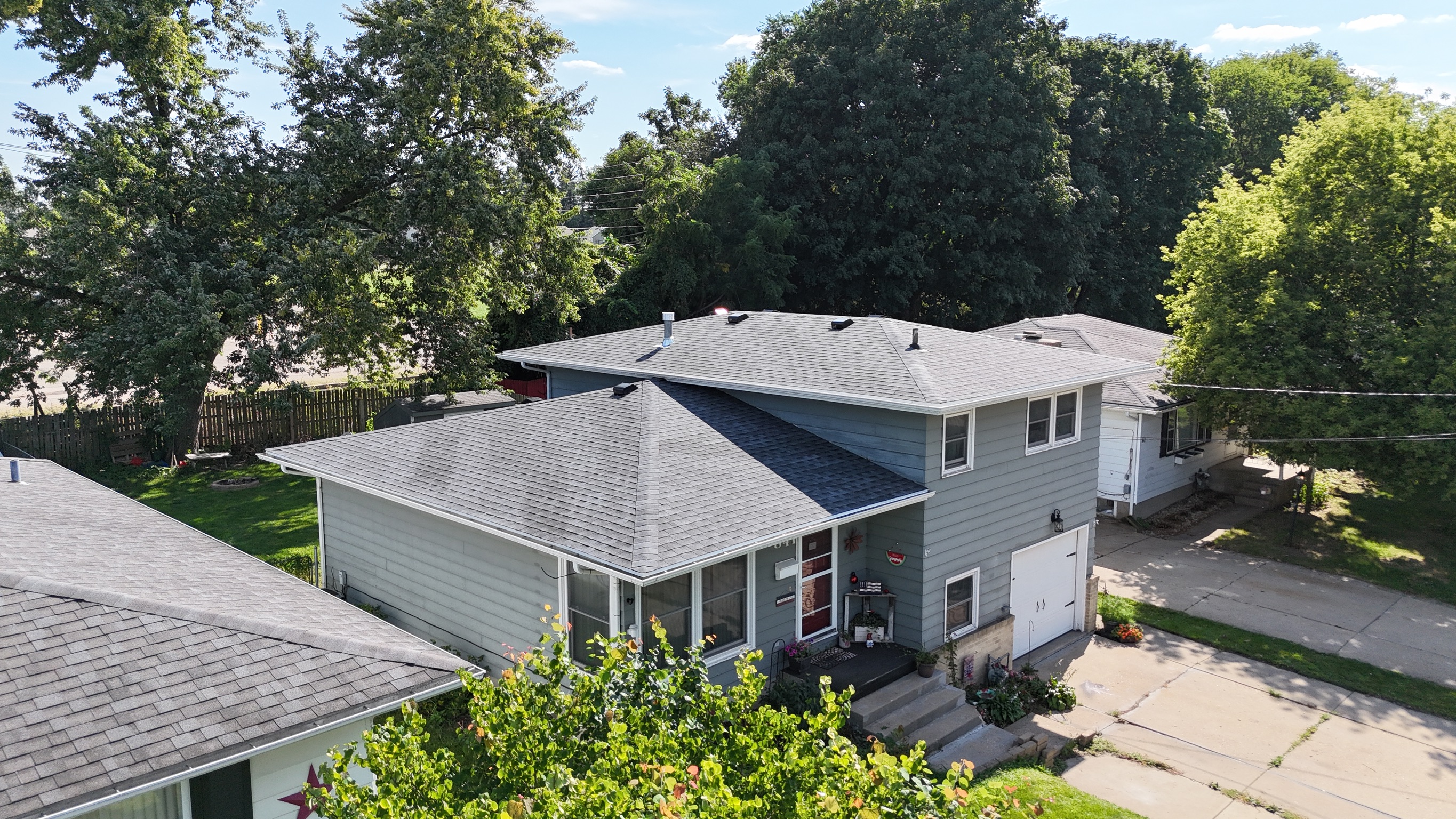 Completed gray shingle roof replacement on a multi-level residential home.