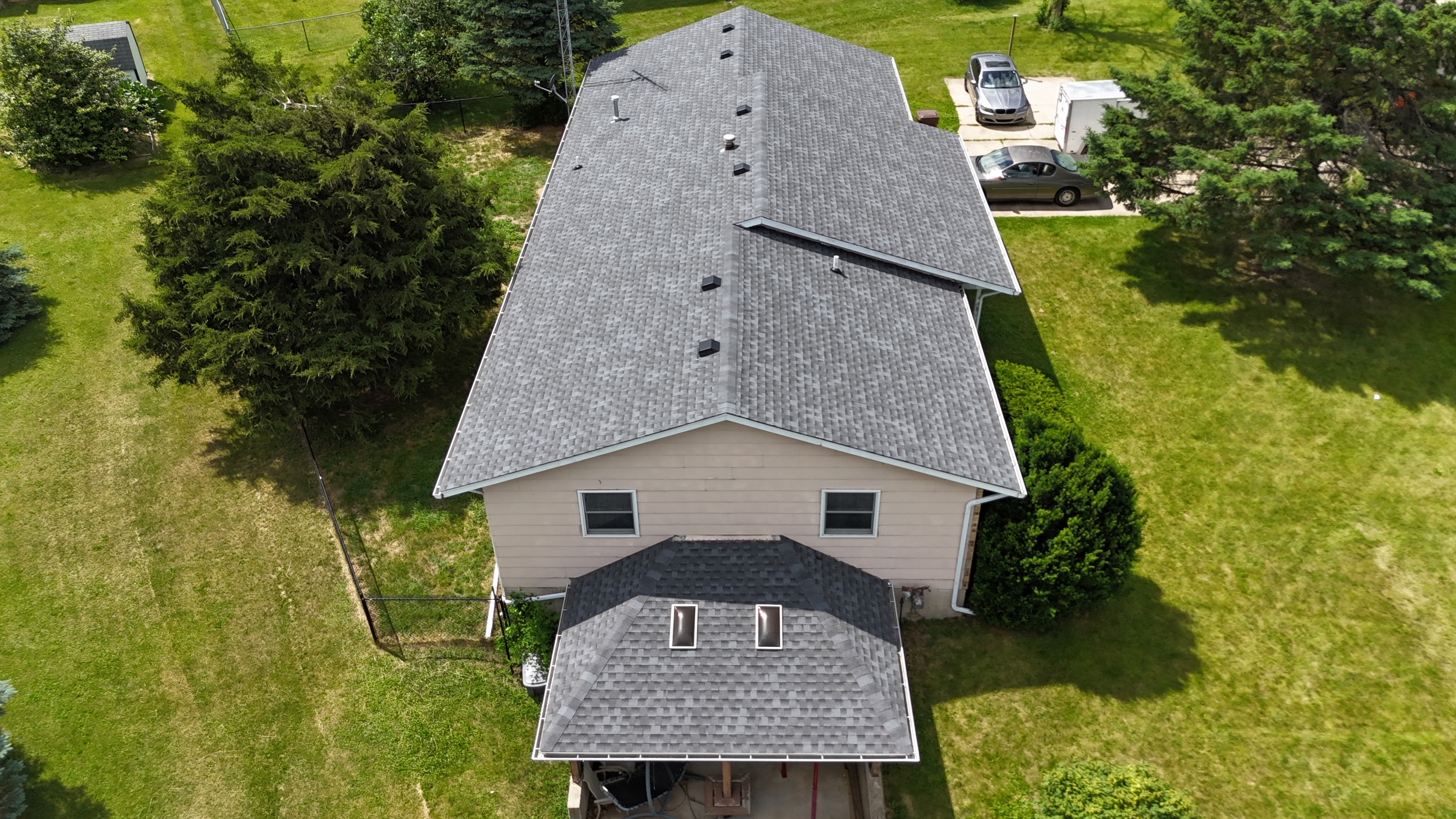 Side view of a house with a newly installed shingle roof.
