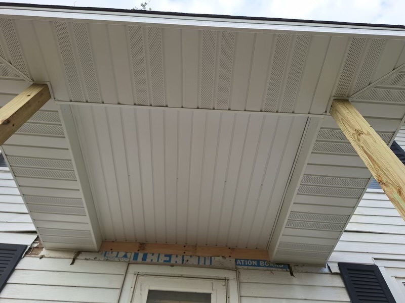 Clean white siding panels installed on a porch ceiling area.