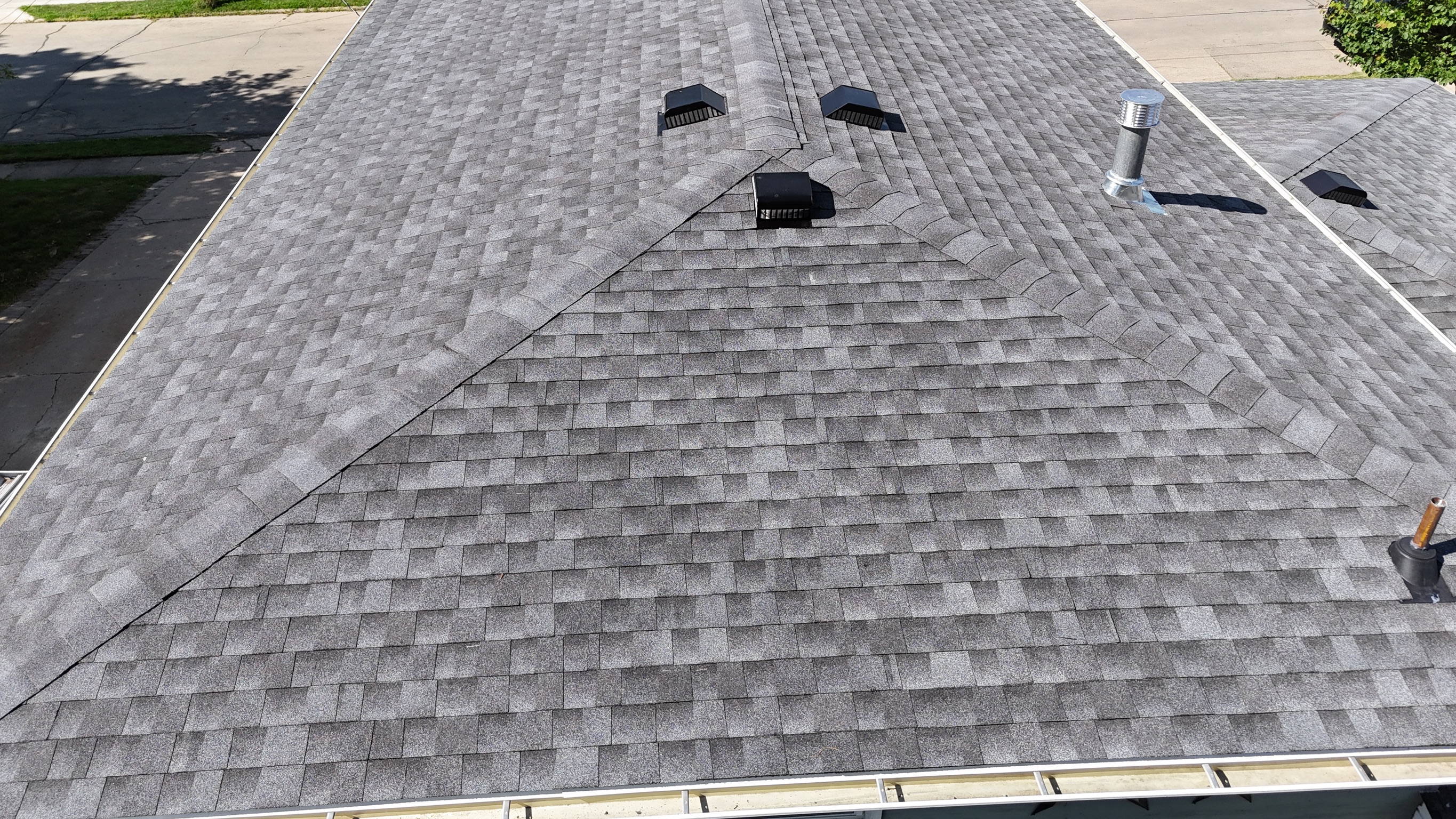 Top-down aerial view of a clean, finished dark gray shingle roof.