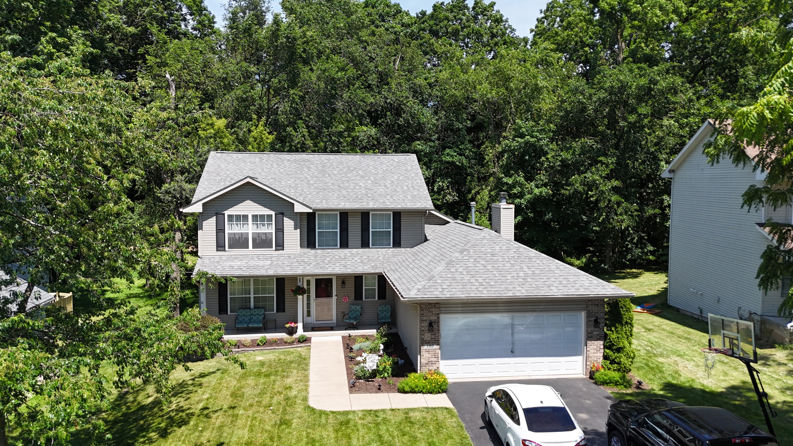 Drone shot of a completed residential roofing project next to a driveway.