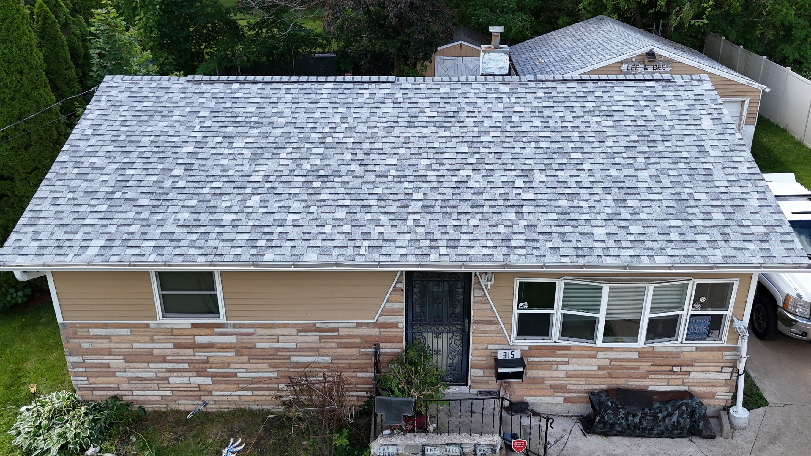 Completed roofing project showing clean asphalt shingles and ridge caps.