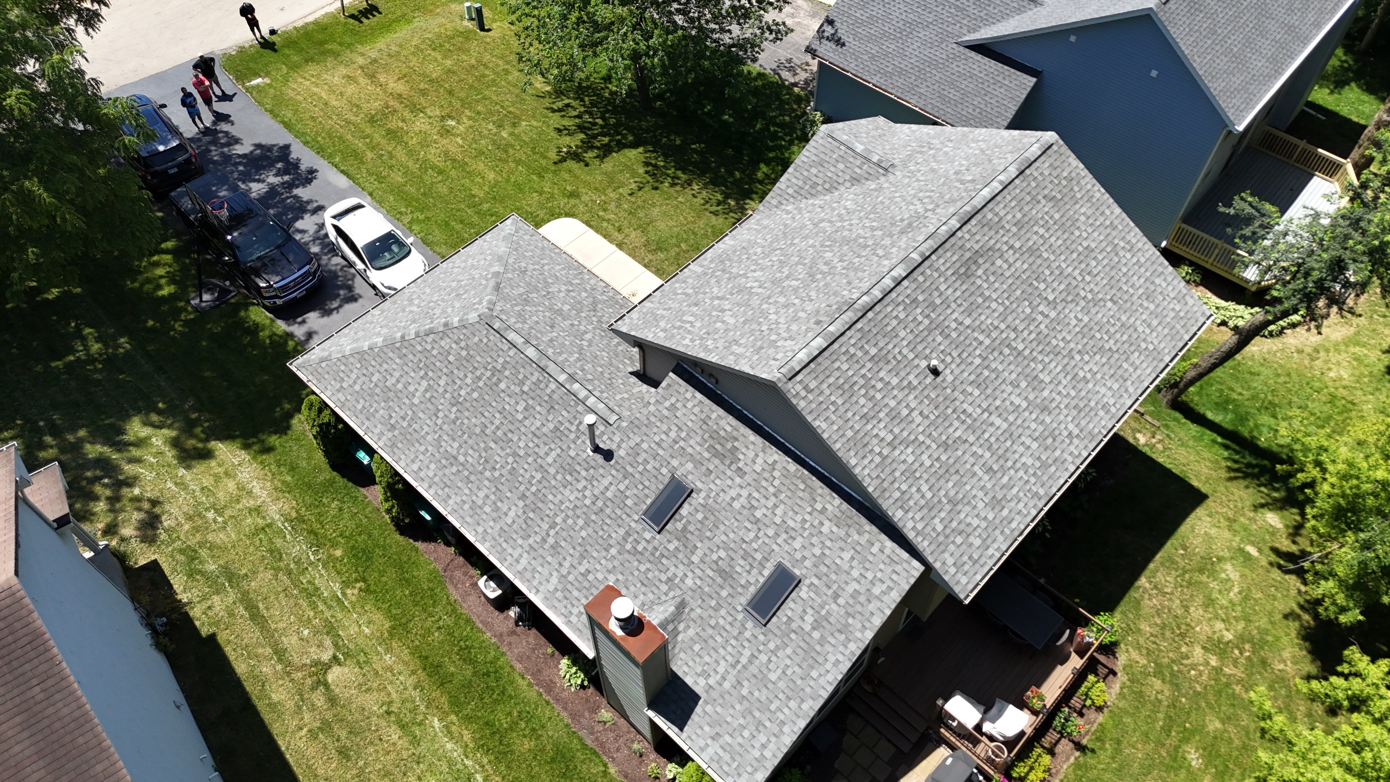 Completed roofing project showing clean lines and new dark shingles by Precision Exteriors Inc.