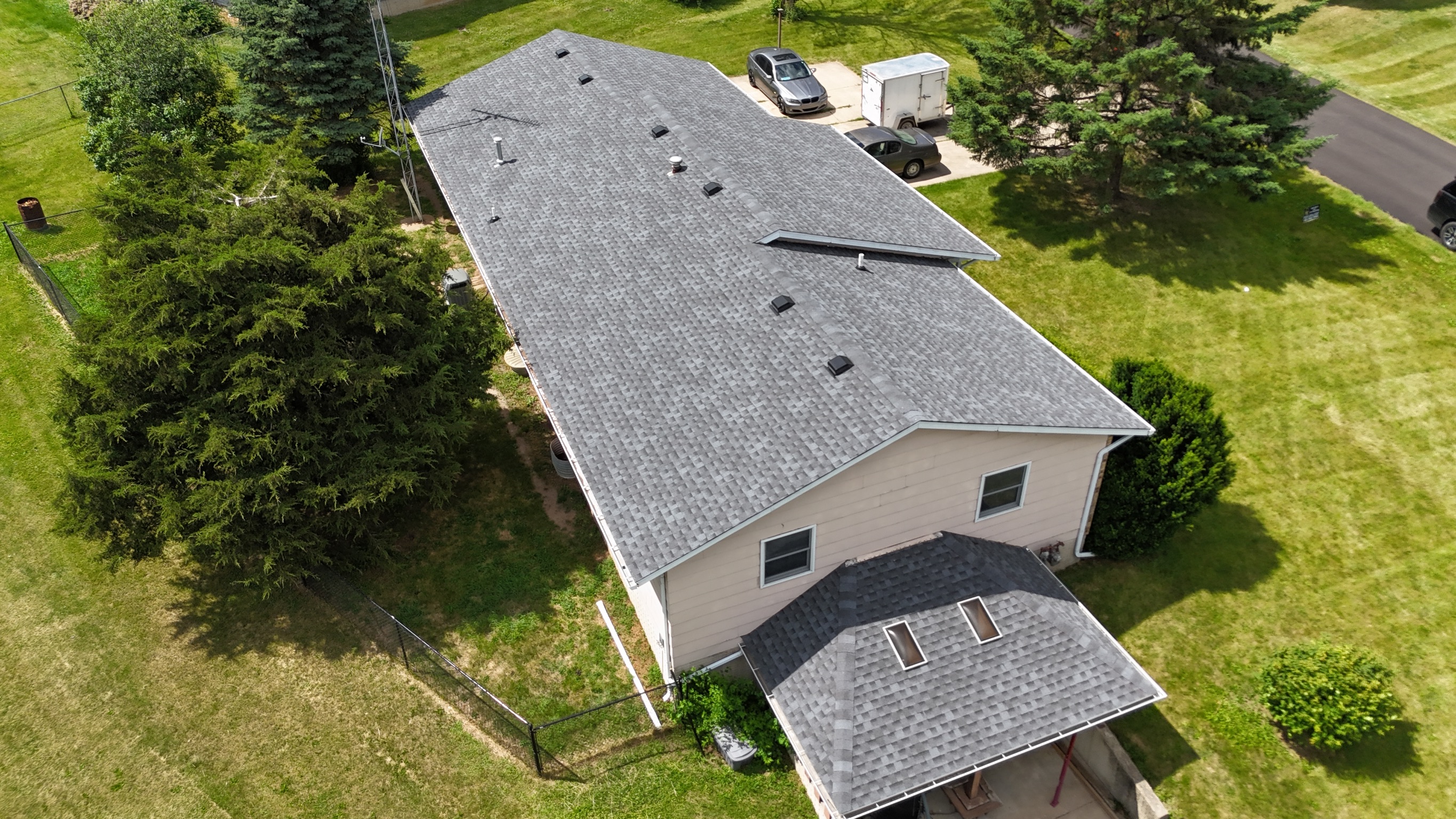 Drone shot of a completed multi-gabled shingle roof replacement.