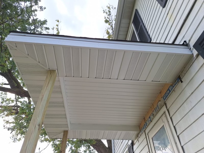 Underneath view of newly completed soffit and trim work on a home porch.