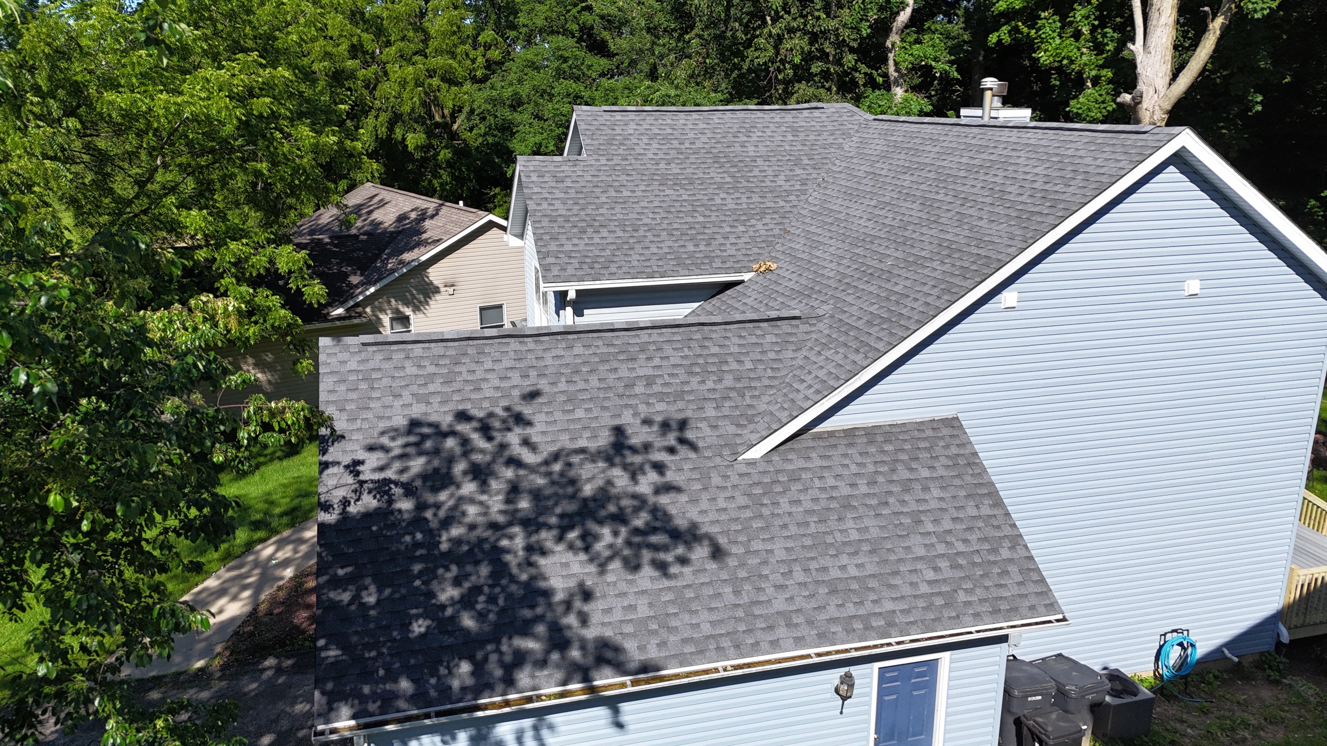Aerial view of a clean, newly installed dark gray shingle roof.