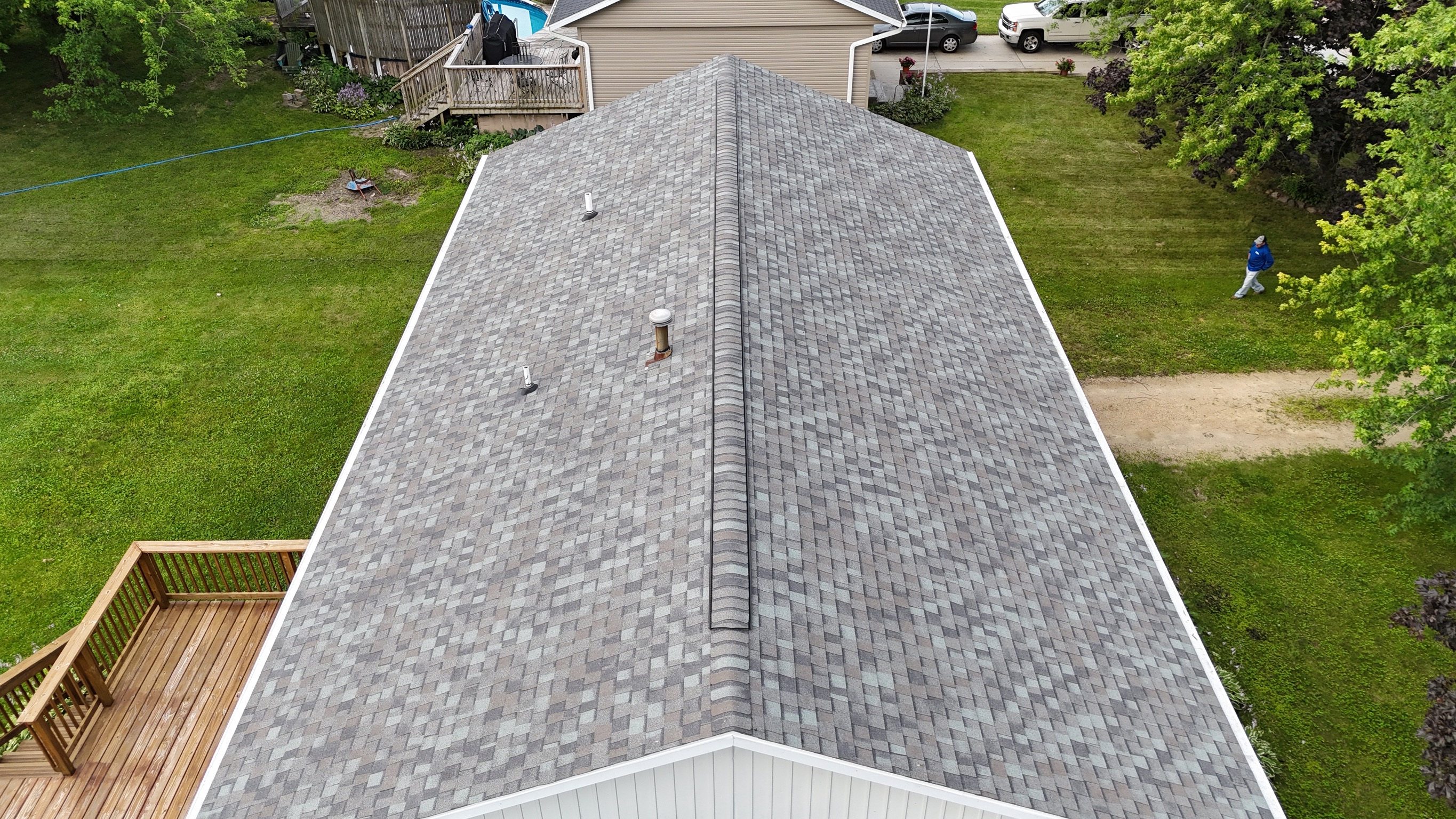 Aerial drone perspective of a finished light gray shingle roof.
