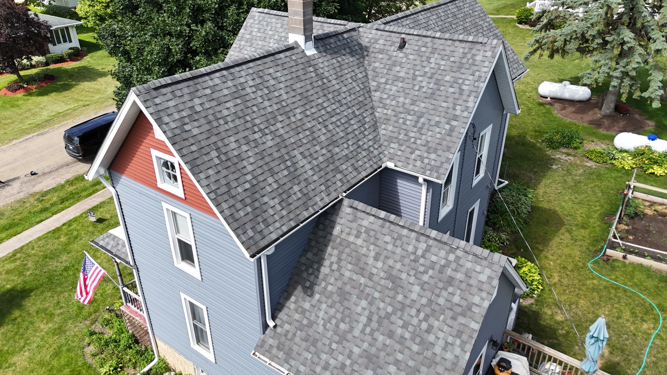 Drone perspective of a finished residential roof replacement by Precision Exteriors Inc.
