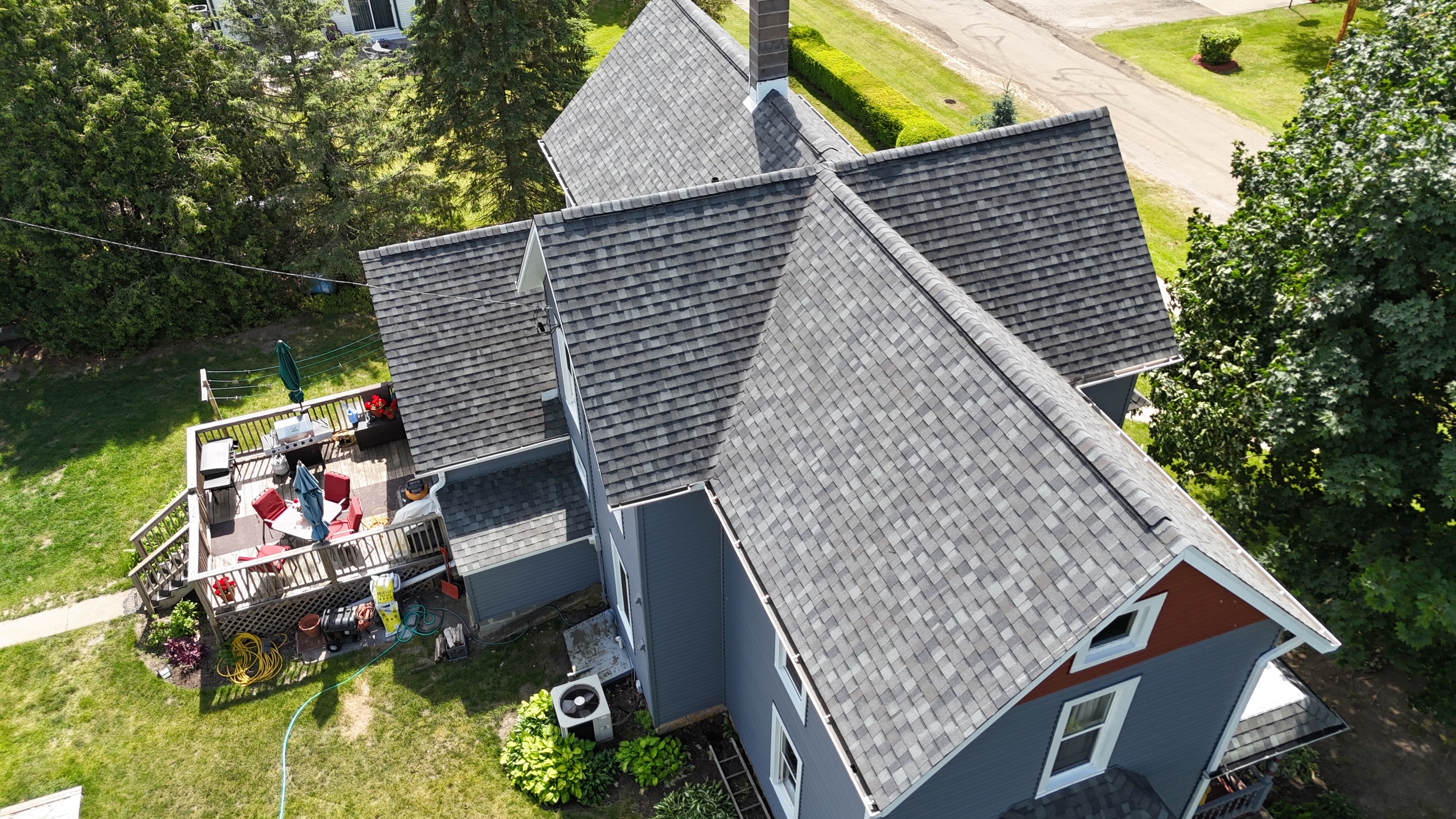 Completed gray architectural shingle roof on a suburban house.