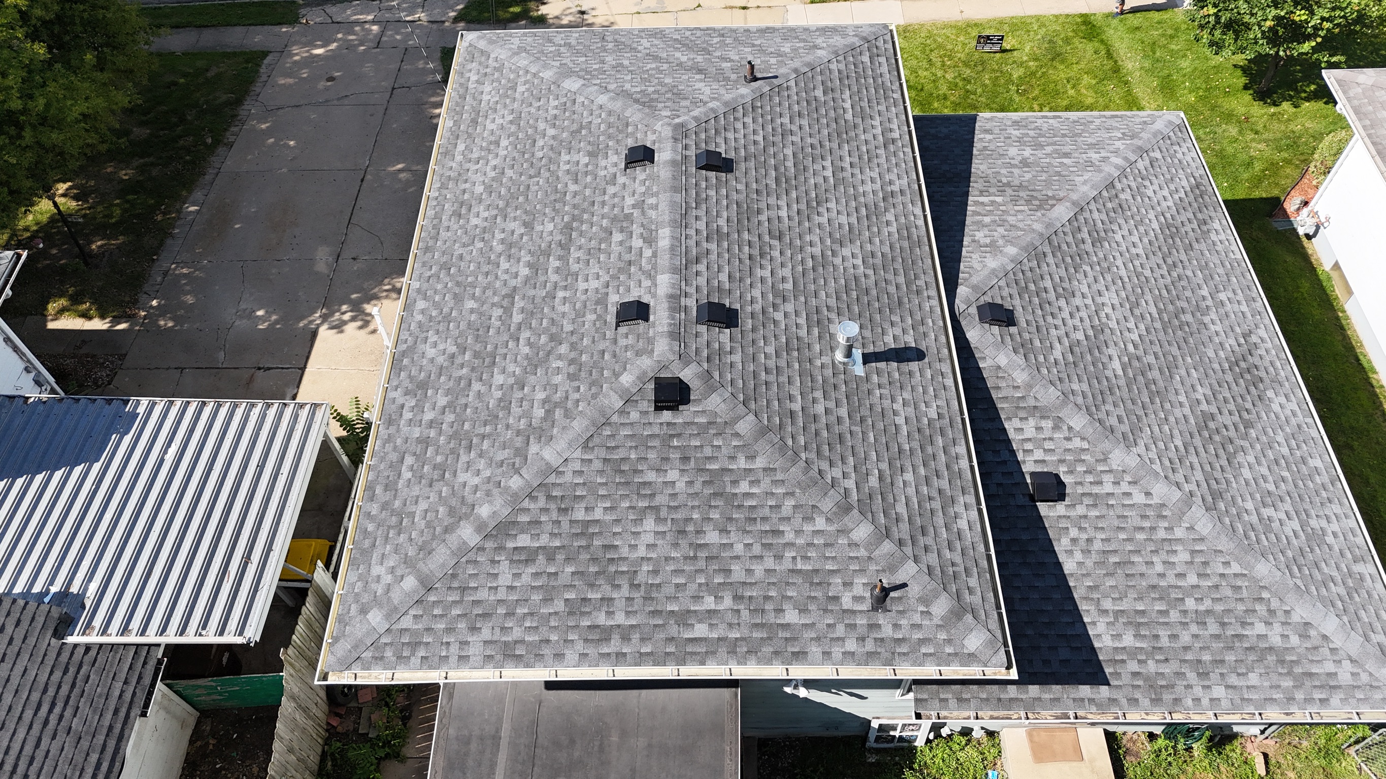 Aerial view of high-quality roofing shingles installed on a gabled roof by Precision Exteriors Inc.