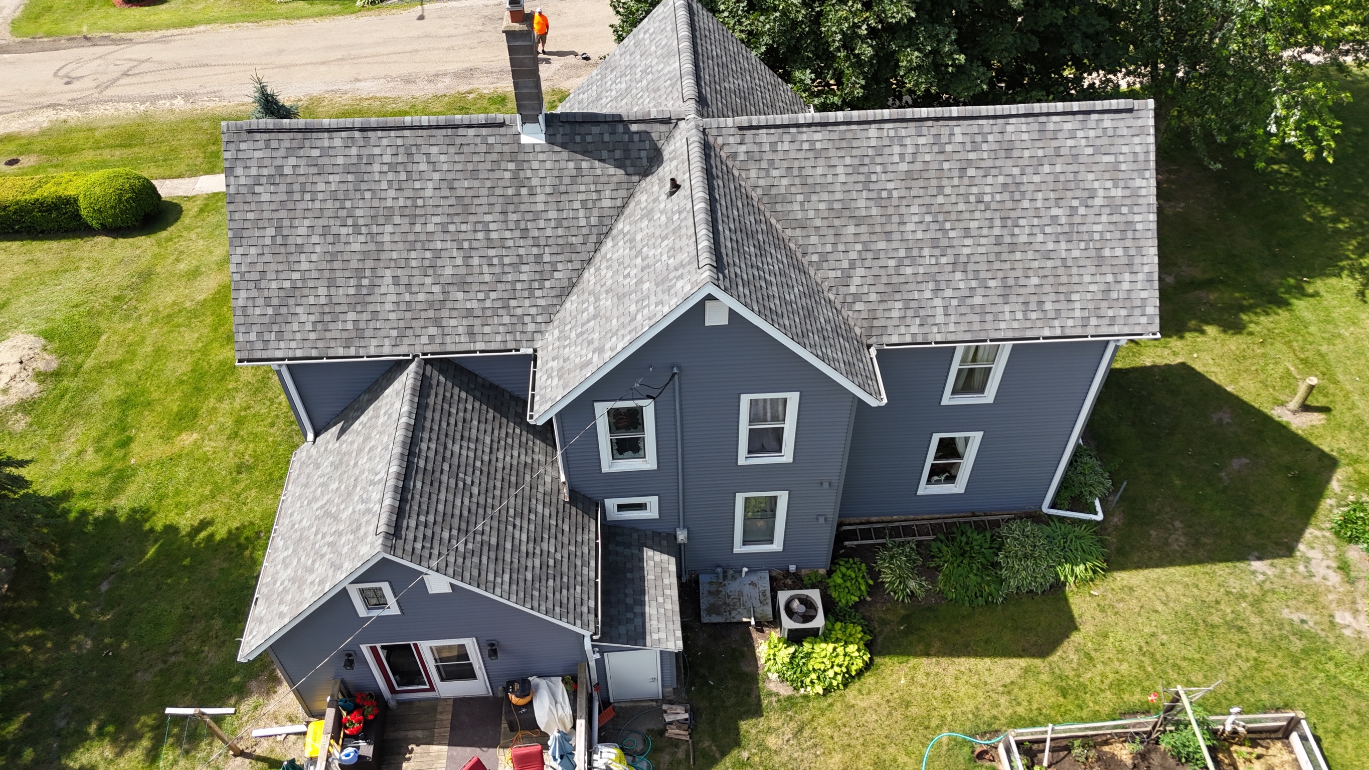Aerial drone view of a completed dark gray shingle roof.