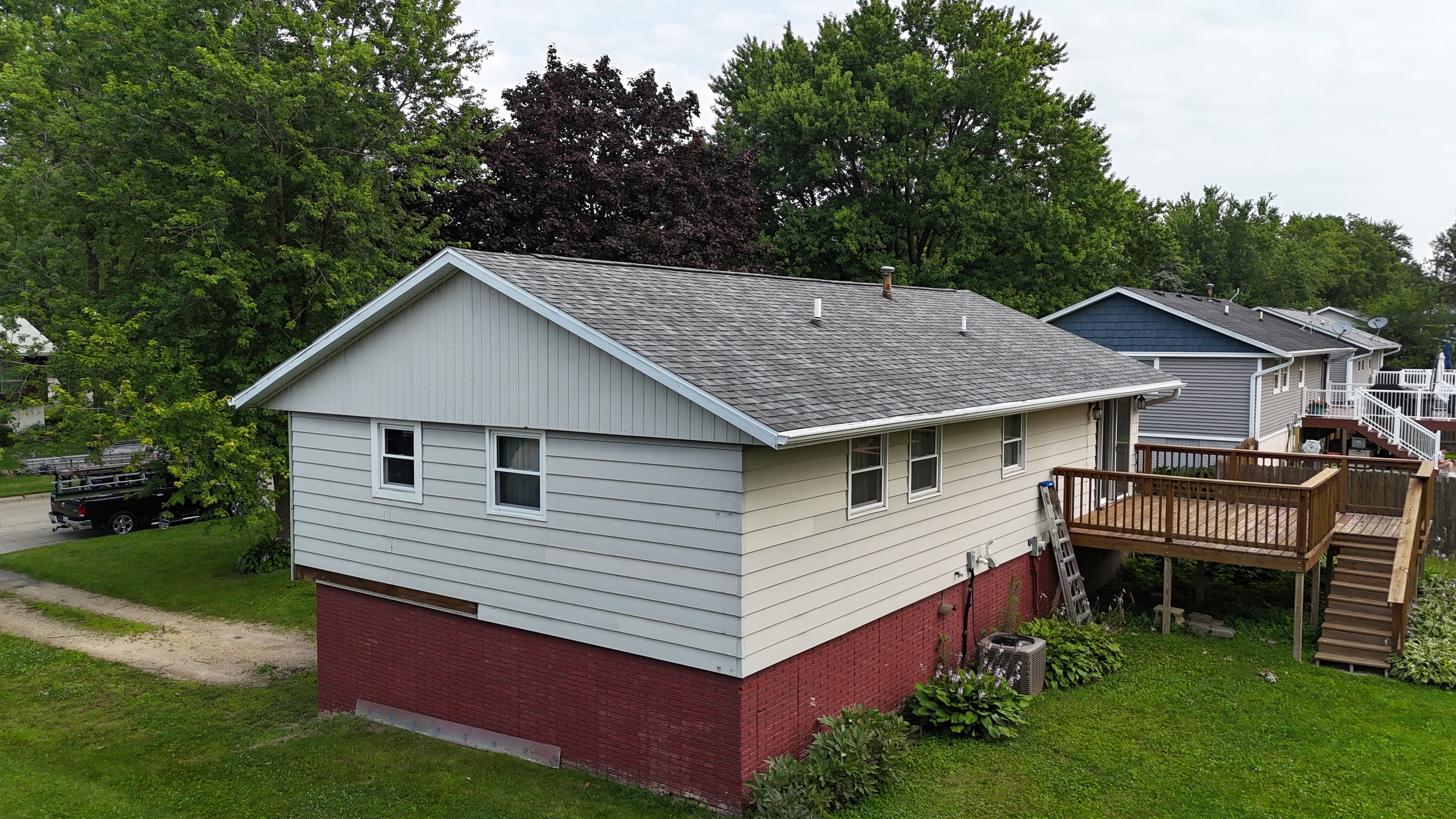 Aerial view of a newly replaced gray asphalt shingle roof by Precision Exteriors Inc.