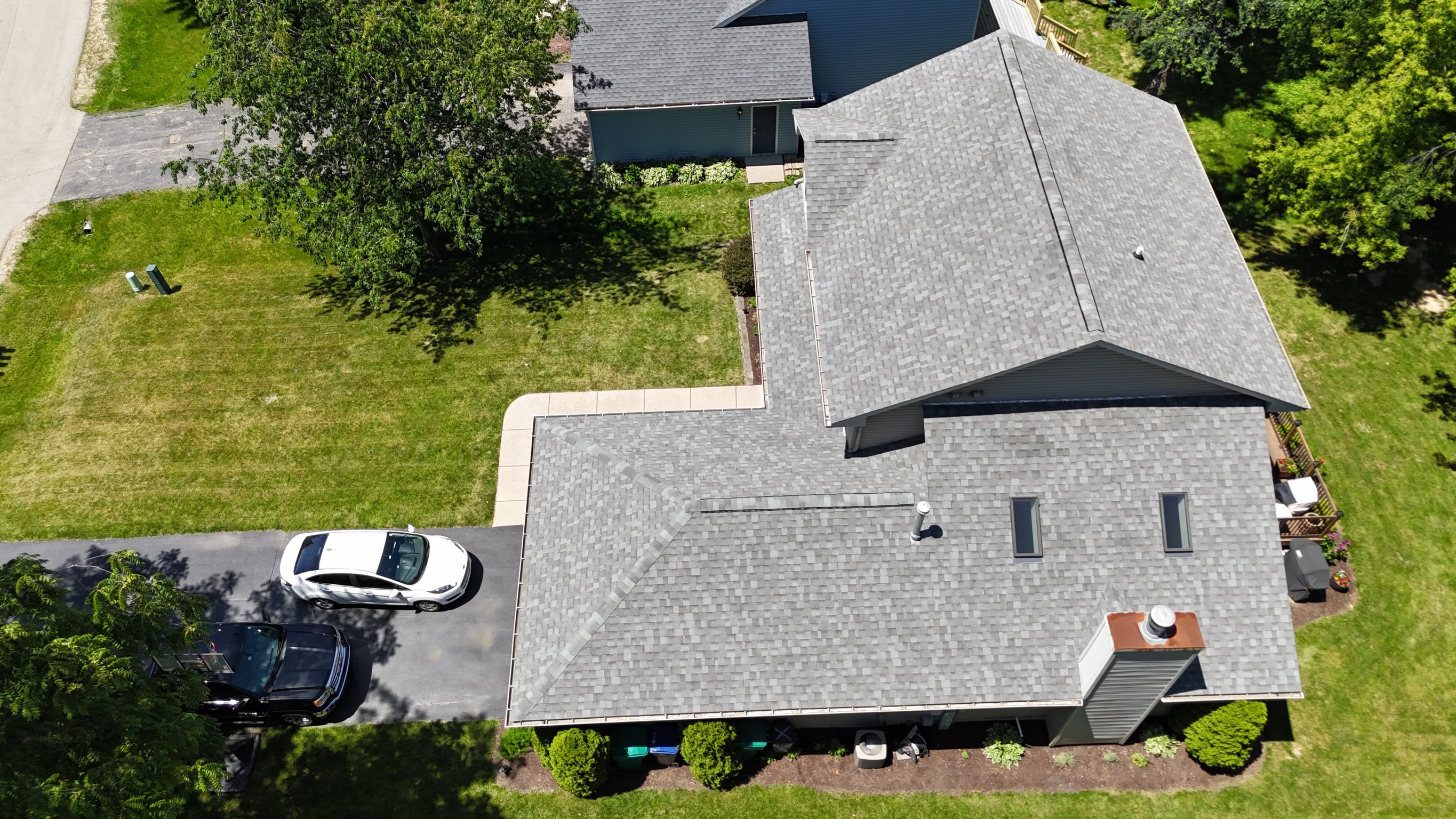 Completed residential roof installation featuring dark gray shingles by Precision Exteriors Inc.