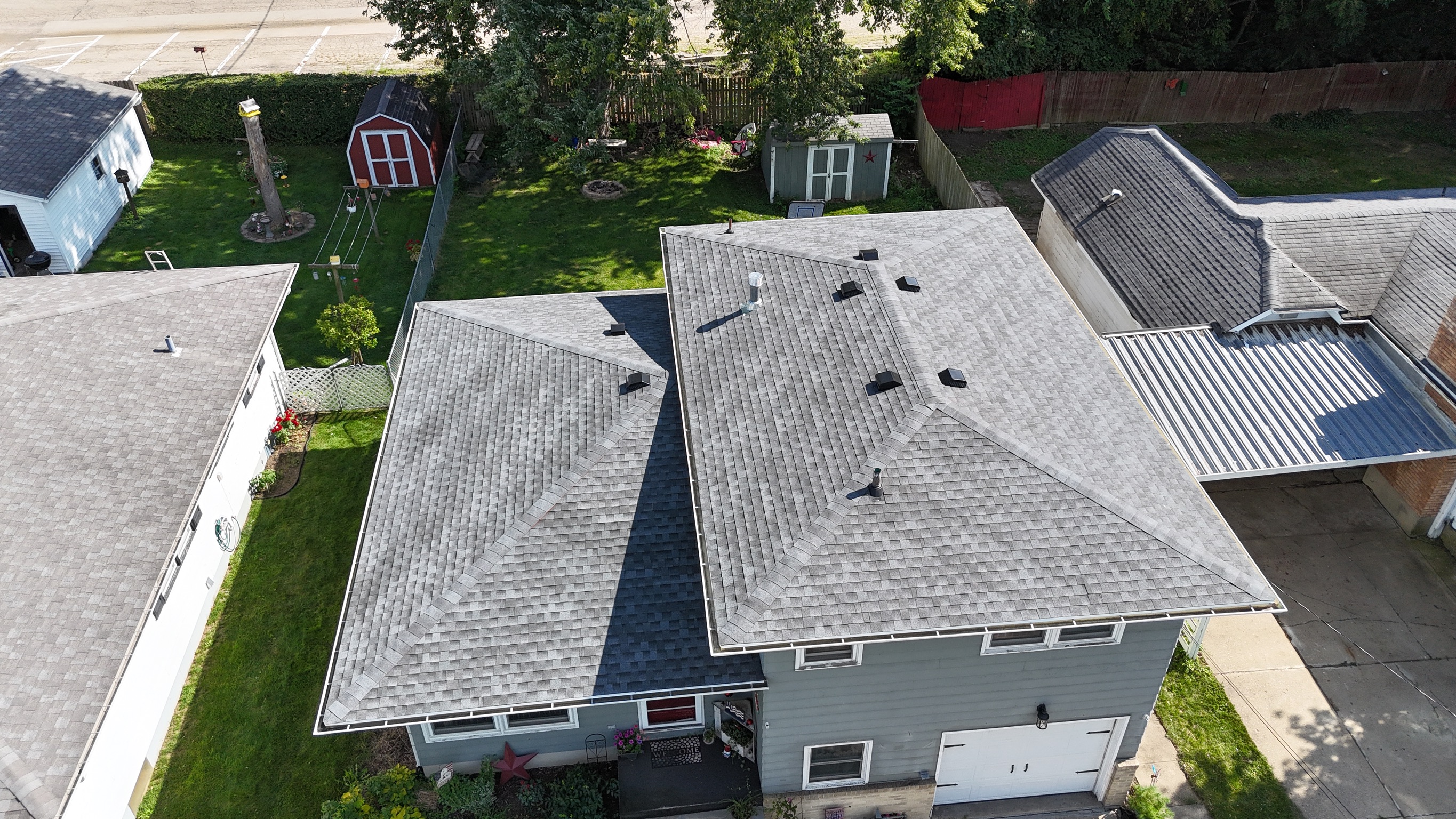 Finished light gray shingle roof on a two-story residential property.