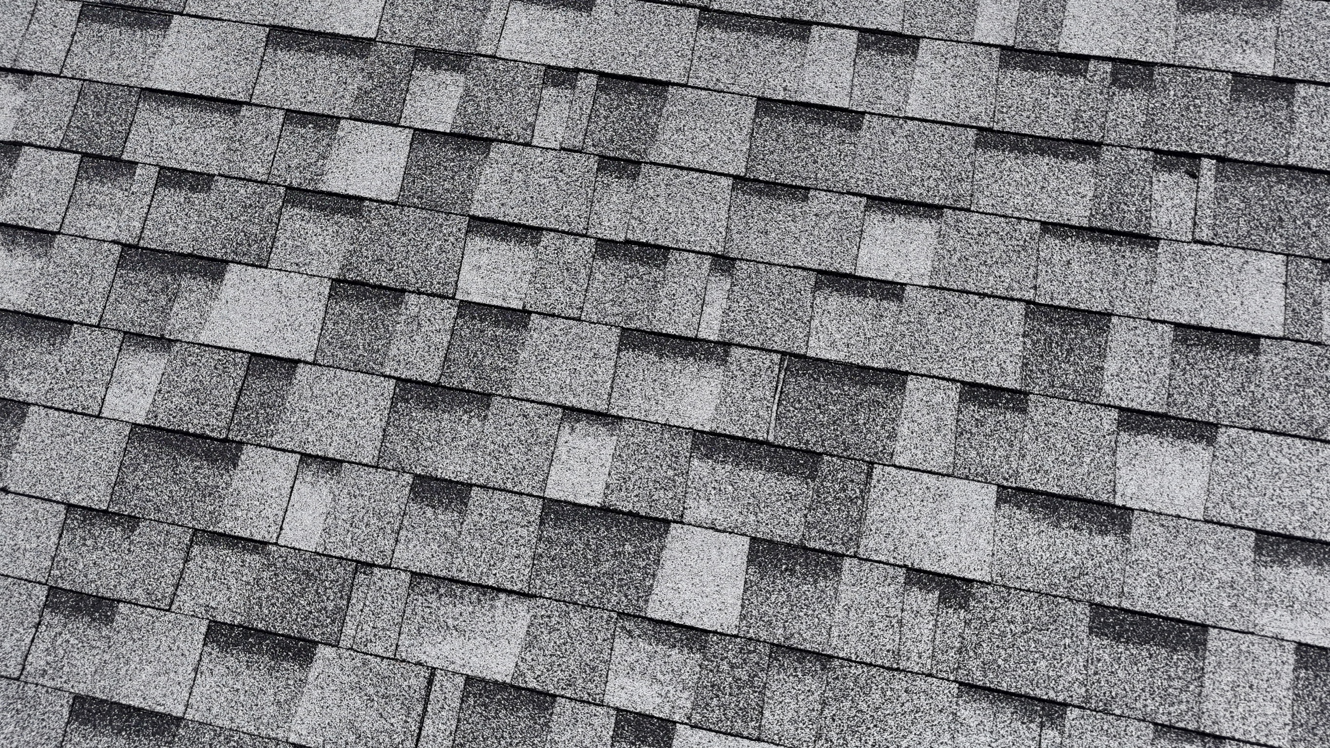 Aerial drone view of a finished slate gray shingle roof replacement by Precision Exteriors Inc.