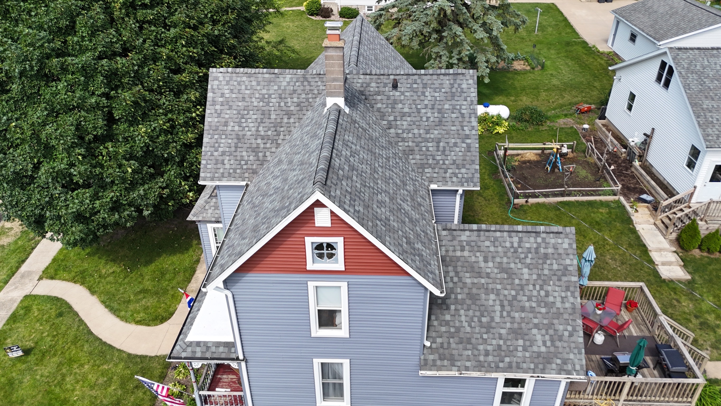 New slate gray architectural shingles installed on a suburban home.