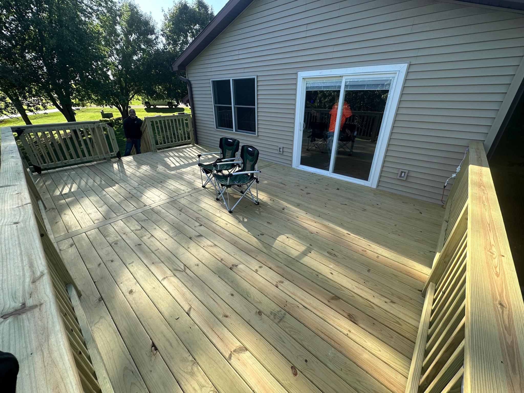 Expansive custom wood backyard deck with matching safety guardrails built by Precision Exterior Inc. for a home in the Lena, IL area.