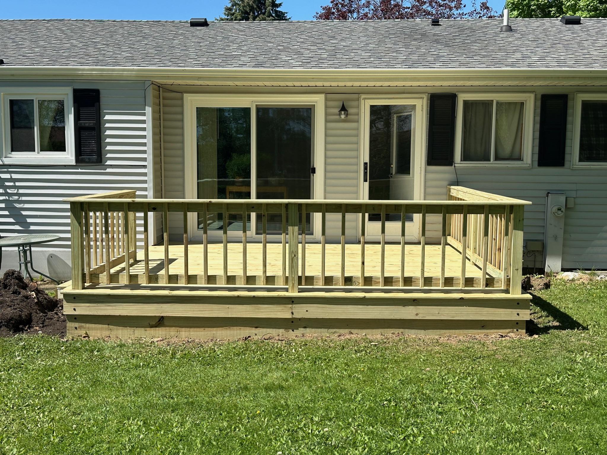 New treated-wood platform deck and safety railing built by Precision Exterior Inc. for a residential backyard in Lena, IL.