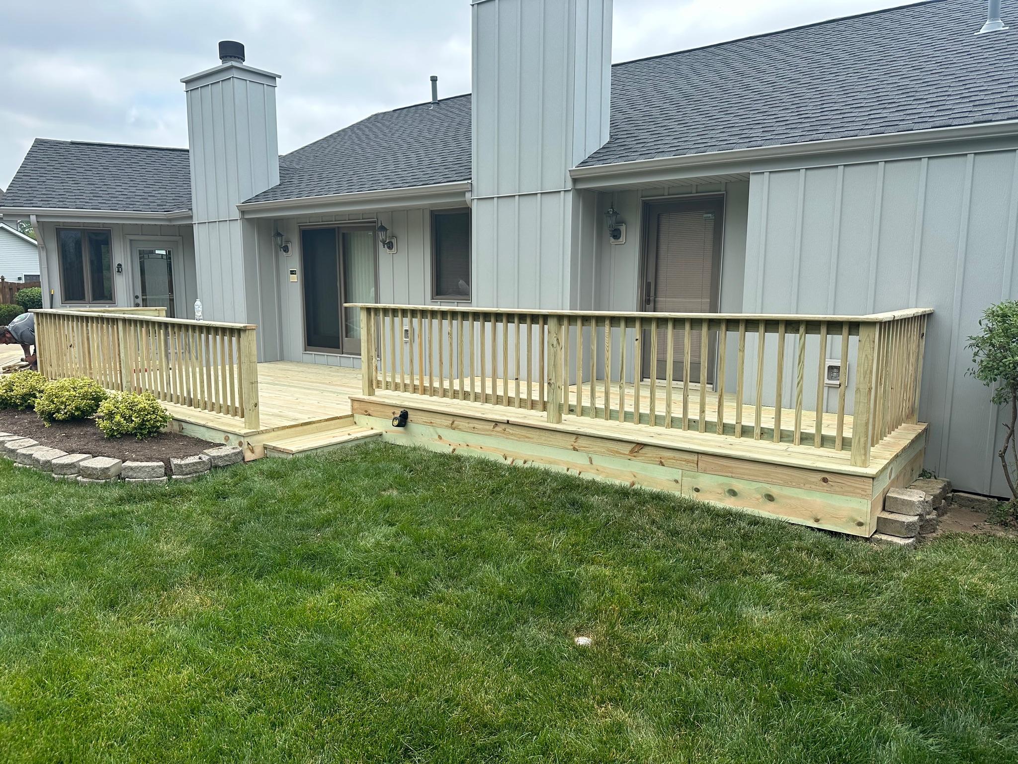 Custom multi-level pressure-treated wood deck and safety guardrails built by Precision Exterior Inc. for a residential property in Lena, IL.