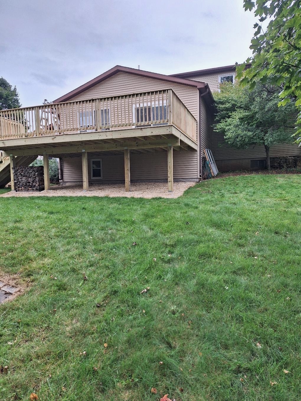 High-elevation backyard pressure-treated wood deck with wood safety railings and side stairs built by Precision Exterior Inc.