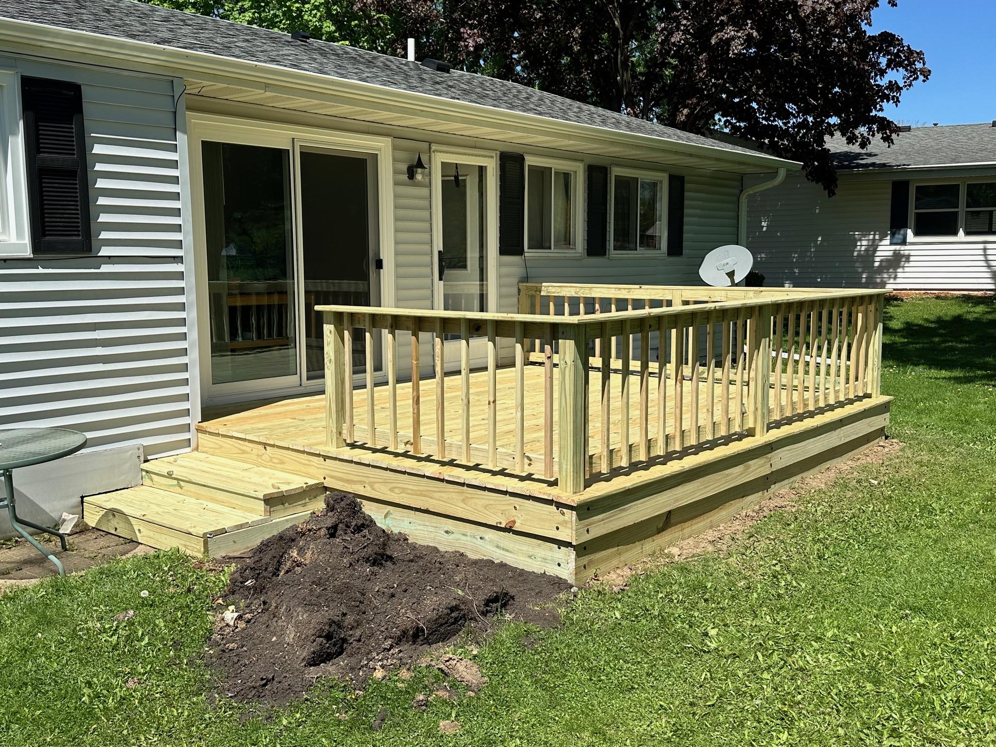 New wooden backyard platform deck and safety railing built by Precision Exterior Inc. for a residential home in Lena, IL.
