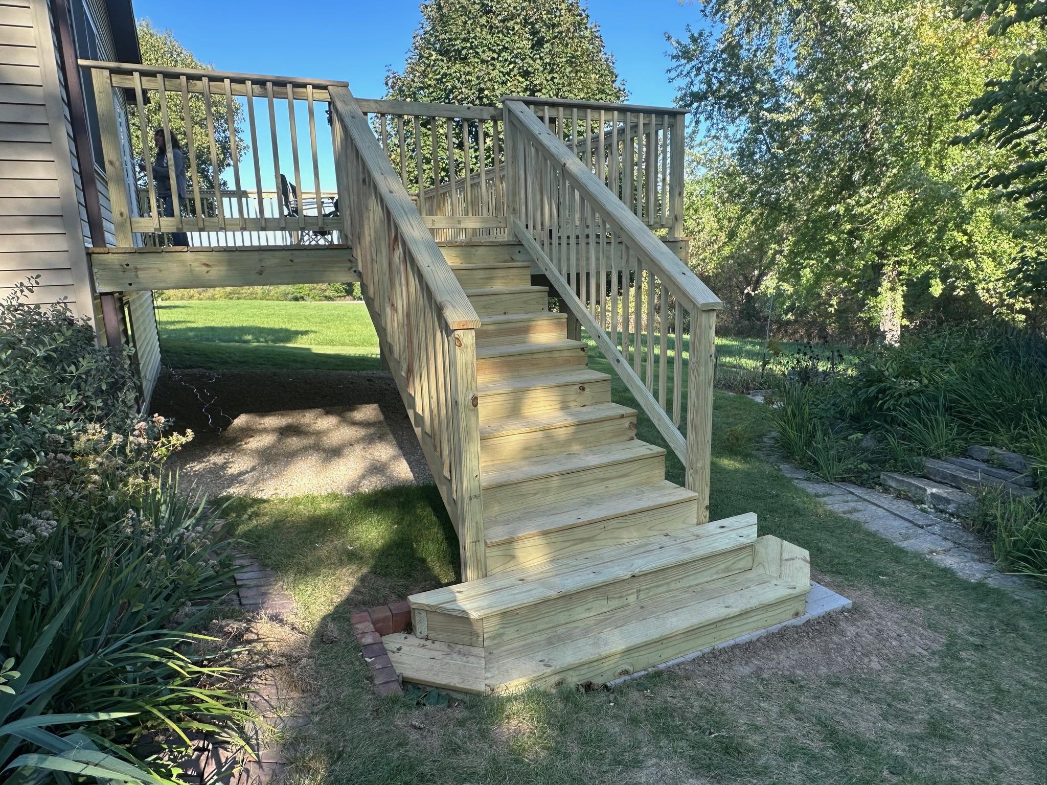 Custom elevated wood deck and staircase with a secure railing system installed by Precision Exterior Inc. for a residential home in Lena, IL.