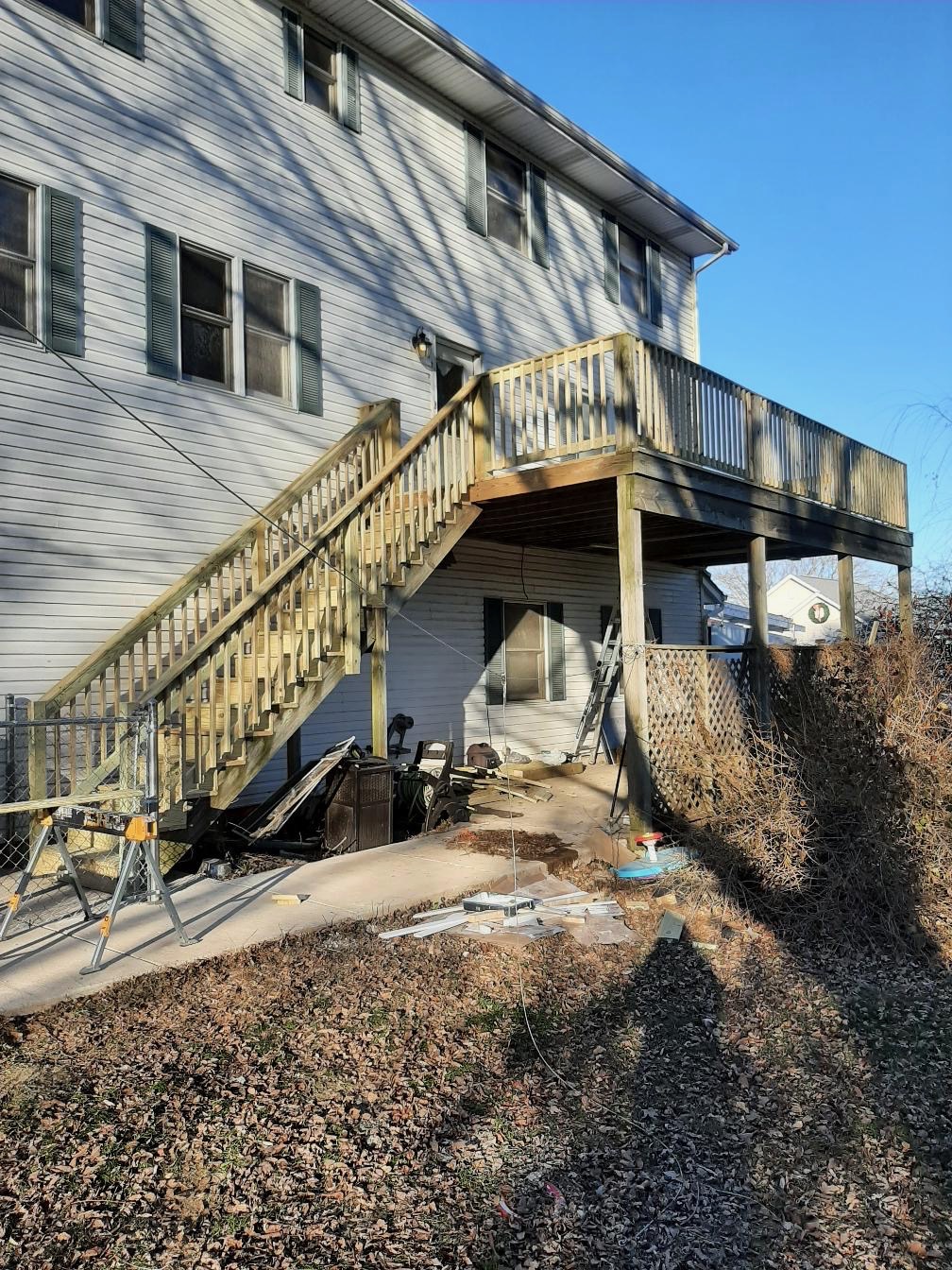 Elevated second-story pressure-treated wood deck and staircase installation on a residential home by Precision Exterior Inc.