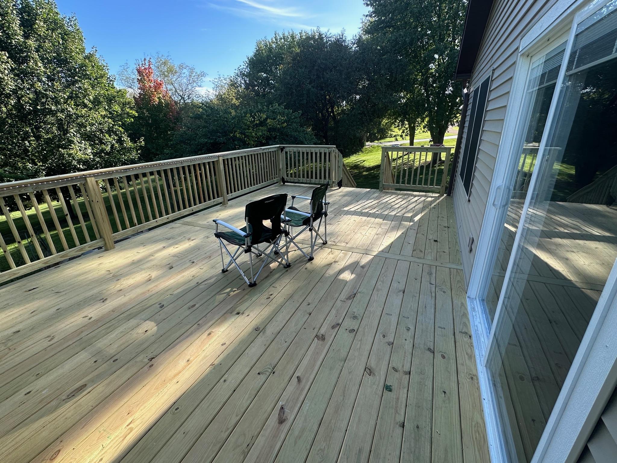 Large custom wood backyard deck with matching guardrails built by Precision Exterior Inc. for a residential home in Lena, IL.